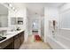 Bathroom with double vanity, soaking tub, and a walk-in shower at 875 Fillmore Ct, Davenport, FL 33837