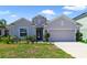 Single-story home with two-car garage and landscaped yard at 875 Fillmore Ct, Davenport, FL 33837