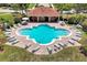 Community pool with surrounding lounge chairs and a covered patio area at 3587 Casalta Cir, New Smyrna Beach, FL 32168