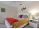 Cozy bedroom with a white bed frame, orange blanket, and coastal artwork at 3587 Casalta Cir, New Smyrna Beach, FL 32168