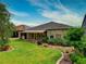 Landscaped backyard with stone pathway and retractable awning at 251 Silver Maple Rd, Groveland, FL 34736