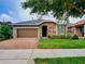 Curb appeal abounds in this one-story home featuring a brick paver driveway and lush landscaping at 251 Silver Maple Rd, Groveland, FL 34736