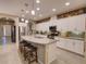 Open kitchen with white cabinets, granite island, and stainless steel appliances at 251 Silver Maple Rd, Groveland, FL 34736