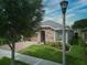 One-story home with stone accents, landscaping, and a brick driveway at 251 Silver Maple Rd, Groveland, FL 34736