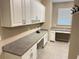Laundry room with built-in cabinets, a workspace, and modern appliances at 251 Silver Maple Rd, Groveland, FL 34736