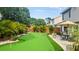 Spacious backyard oasis with a putting green, patio furniture, and lush landscaping at 4436 Yachtmans Ct, Orlando, FL 32812