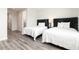 Guest bedroom with two twin beds and hardwood floor at 1136 Castle Pines Ct, Reunion, FL 34747