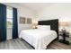Spacious bedroom with king-size bed, dark headboard, and blue curtains at 1136 Castle Pines Ct, Reunion, FL 34747