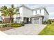 Modern two-story home with gray stone and two garages at 1136 Castle Pines Ct, Reunion, FL 34747