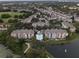 Aerial view of community with lake, pool, and numerous homes at 3446 Soho St # 304, Orlando, FL 32835