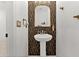 Stylish powder room with pedestal sink and geometric patterned wall at 3846 Cabo Rojo Dr, Saint Cloud, FL 34772