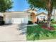 Inviting home exterior with a two-car garage and well-manicured lawn at 114 Castlemain Cir, Davenport, FL 33897