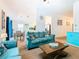 Open concept living area with teal sofas and dining area view at 114 Castlemain Cir, Davenport, FL 33897