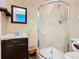 Bathroom with a rounded glass shower and dark vanity at 114 Castlemain Cir, Davenport, FL 33897