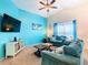 Living room featuring teal sofas, large TV, and wood coffee table at 114 Castlemain Cir, Davenport, FL 33897