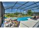 Relaxing pool area with covered patio, lounge chairs, and lush landscaping at 5204 Oakbourne Ave, Davenport, FL 33837