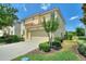 Two-story house with tan walls, tile roof, and a two-car garage at 5204 Oakbourne Ave, Davenport, FL 33837