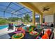 Covered patio with comfortable seating and dining area overlooking the pool at 5204 Oakbourne Ave, Davenport, FL 33837