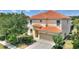 Two-story house with terracotta tile roof, two-car garage, and landscaping at 5204 Oakbourne Ave, Davenport, FL 33837
