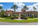 Community clubhouse with palm trees and a well-manicured lawn at 5500 Metrowest Blvd # 304, Orlando, FL 32811