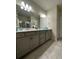 Double vanity bathroom with gray cabinets and a large mirror at 2590 Cliff Way, Saint Cloud, FL 34771
