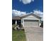 House exterior featuring a two-car garage and landscaped yard at 2590 Cliff Way, Saint Cloud, FL 34771
