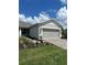 House exterior featuring a two-car garage and landscaped yard at 2590 Cliff Way, Saint Cloud, FL 34771