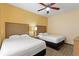 Bright bedroom with two twin beds, nightstands, and ceiling fan at 12544 Floridays Resort Dr # 503-B, Orlando, FL 32821