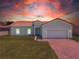 One-story house with a two-car garage at sunset at 421 Cinnamon Dr, Kissimmee, FL 34759