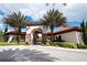Gated community entrance with palm trees and Spanish-style architecture at 4611 Terrasonesta Dr, Davenport, FL 33837