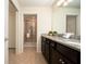 Clean bathroom with granite countertops, dark brown cabinets, and a walk-in shower at 4611 Terrasonesta Dr, Davenport, FL 33837