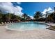Circular resort-style pool with lounge chairs and palm trees at 4611 Terrasonesta Dr, Davenport, FL 33837