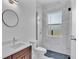 Modern bathroom with marble shower, vanity, and round mirror at 134 Blazing Star Ave, Lake Alfred, FL 33850