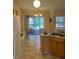 Bright kitchen features wood cabinets, tile floor, and access to a screened porch at 1124 Chateau Cir, Minneola, FL 34715