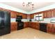 Kitchen with wood cabinets, black appliances, and tile flooring at 2037 Apricot Dr, Deltona, FL 32725