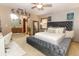 Spacious main bedroom with a tufted gray bed and en-suite bathroom at 2037 Apricot Dr, Deltona, FL 32725