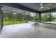 Spacious screened porch with tiled floor, ceiling fan, and tranquil wooded views at 35635 High Pines Dr, Eustis, FL 32736