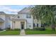 Two-story townhome with light beige siding and landscaping at 200 Southern Pecan Cir # 105, Winter Garden, FL 34787
