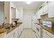 Galley-style kitchen with white cabinets and granite countertops at 200 Southern Pecan Cir # 105, Winter Garden, FL 34787