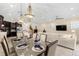 Elegant dining room with a glass-top table and chandelier, adjoining the kitchen and living room at 860 Desert Mountain Ct, Reunion, FL 34747