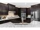 Modern kitchen with dark cabinetry, granite countertops, and stainless steel appliances at 860 Desert Mountain Ct, Reunion, FL 34747