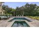 Inviting pool and spa with lounge chairs, surrounded by a paved patio and lush landscaping at 860 Desert Mountain Ct, Reunion, FL 34747