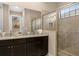 Double vanity bathroom with granite countertop and large walk-in shower at 860 Desert Mountain Ct, Reunion, FL 34747
