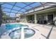 Inviting pool and spa with screened enclosure and patio furniture at 7049 Oakwood St, Davenport, FL 33837