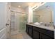 Bathroom features a double vanity, granite countertops and a walk-in shower at 7049 Oakwood St, Davenport, FL 33837