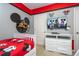 Mickey Mouse themed bedroom with a twin bed and mounted TV at 7049 Oakwood St, Davenport, FL 33837