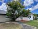 Home's backyard features a large tree and patio at 7313 Cabor Ct, Orlando, FL 32818