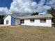 Ranch style home with white and blue exterior, showcasing a spacious yard at 7313 Cabor Ct, Orlando, FL 32818