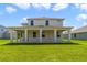 Two-story house with covered patio and grassy backyard at 2993 Water Clover Ct, Apopka, FL 32712