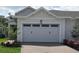 Two-car garage with landscaping and a paved driveway at 2331 Datura Loop, St Cloud, FL 34772